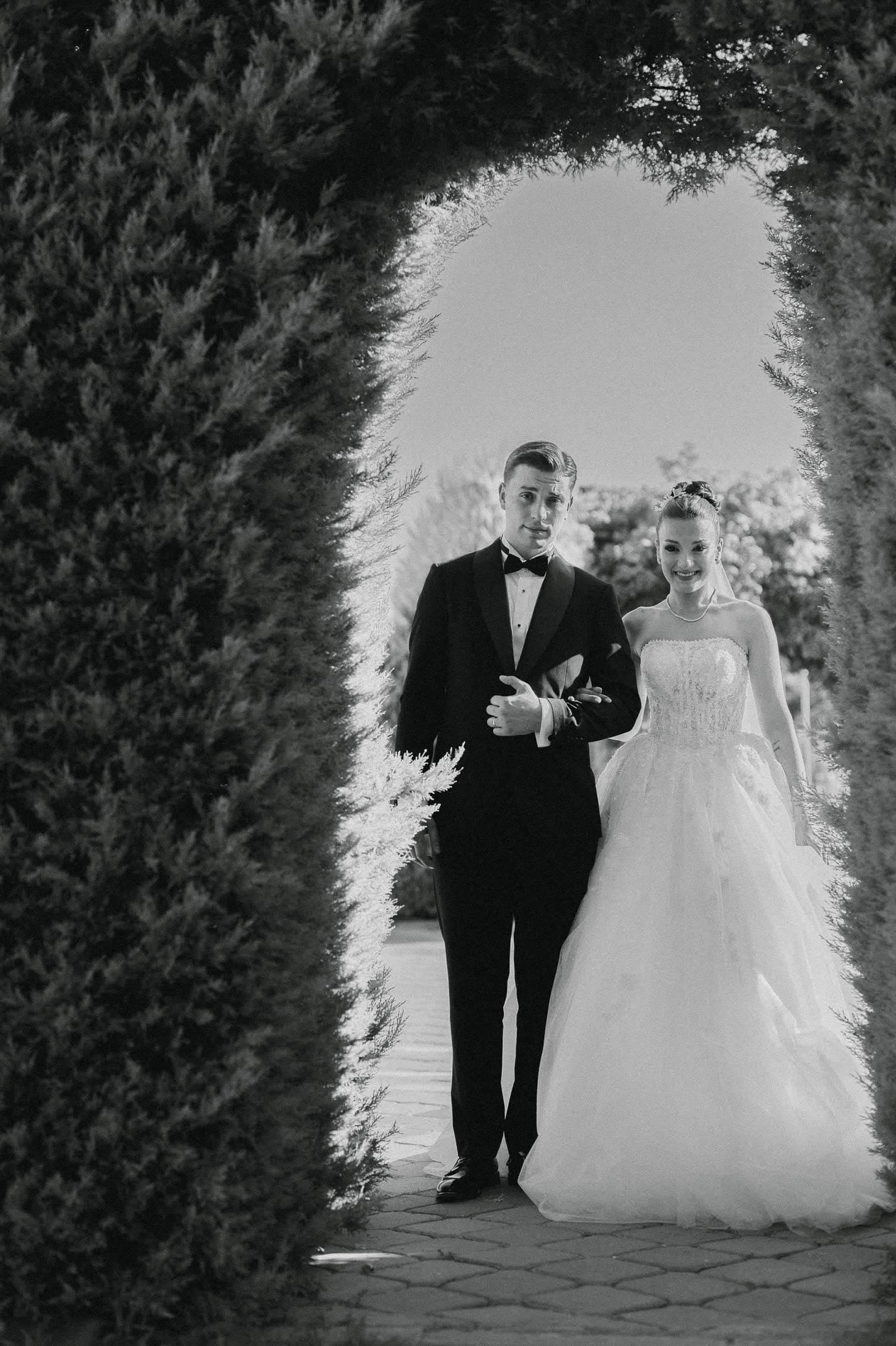 Çit tünelinin içinden yürüyen gelin ve damat