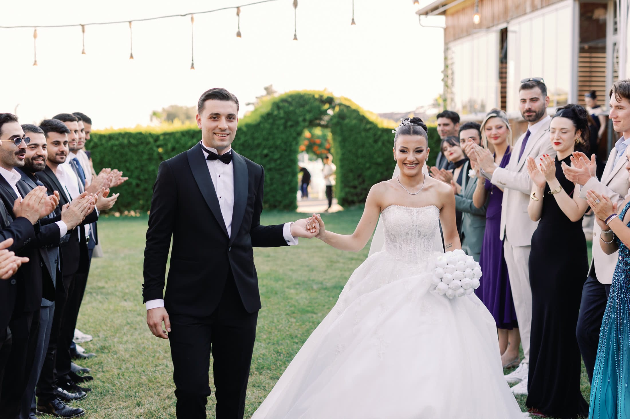Alkışlayan davetlilerin arasından geçen gelin ve damat